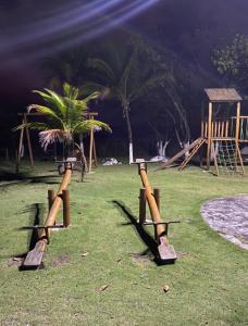 dos bates de béisbol en un campo con palmeras en Casa Sol e Mar Beira-mar, en Ilhéus