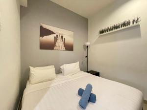 um quarto com uma cama branca com um objecto azul em Park View at Midhills Genting Highlands Free WiFi em Bentong