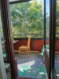a wooden chair sitting on a screened in porch at Boho Apart Ututie in Kotka