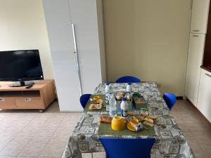 a table with food on it with blue chairs at Bicocca Flat A in Milan