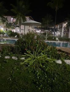 a view of a pool at night with a umbrella at Casa Sol e Mar Beira-mar in Ilhéus