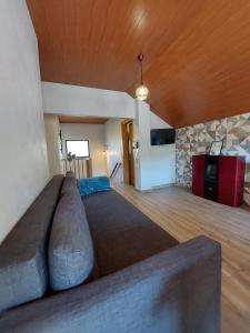 una sala de estar con un sofá grande en una habitación en Miradouros da Aldeia, en Sabugueiro