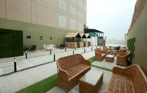 a living room with wicker furniture on a roof at Hotel The Spades in Zirakpur