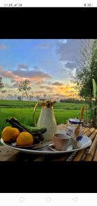 une assiette de fruits et légumes sur une table avec un vase dans l'établissement Tiara Homestay, à Plambi