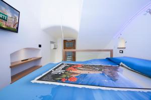 Un dormitorio con una cama azul con una revista. en La dimora del nonno...nel cuore di Amalfi, en Amalfi