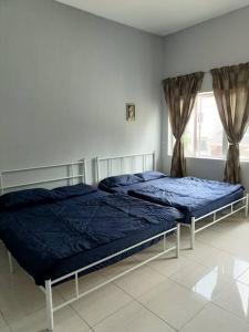 two twin beds in a bedroom with a window at Azzalea Homes 1 @ Taman Golden Hills Cameron Highlands in Brinchang