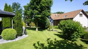 a yard with a house and trees and bushes at Loft in der Natur mit Gartenzugang und Sauna in Herisau