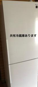 um frigorífico branco com escrita asiática ao lado em 楠のおうち em Yokkaichi