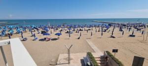 a beach with chairs and umbrellas and the ocean at Condomino Giuditta in Porto Santa Margherita di Caorle