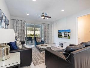 un soggiorno con mobili in pelle e ventilatore a soffitto di Luxurious 6 bedroom Villa with private pool & Spa a Orlando