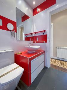 un bagno rosso e bianco con lavandino e servizi igienici di Charming Blasco de Garay - Estancias Temporales a Madrid