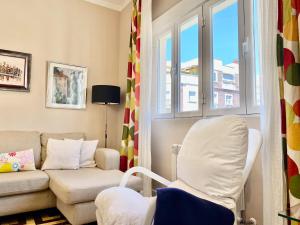 een woonkamer met een bank en een stoel bij Charming Blasco de Garay - Estancias Temporales in Madrid