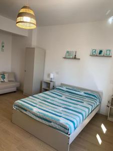 una camera con letto e lenzuola a righe blu e bianche di La Casa di Allegra, Monolocale a Le Grazie - Comune di Portovenere a Portovenere