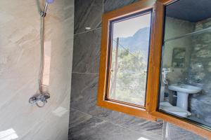 a bathroom with a shower and a sink and a mirror at MANZARA BUNGALOW in Fethiye