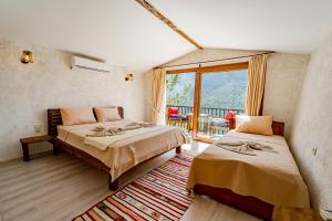 a bedroom with two beds and a balcony at MANZARA BUNGALOW in Fethiye