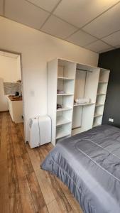 a bedroom with white shelves and a bed at Depto roca in General Roca
