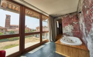 SandiglianoにあるRELAIS CASCINA ERAのバスルーム(バスタブ付)、大きな窓が備わります。