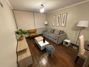 M-Montt Providencia Apartamentos Amoblados في سانتياغو: غرفة معيشة مع أريكة وطاولة