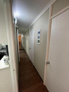 a hallway with white walls and wooden flooring in a room at M-Montt Providencia Apartamentos Amoblados in Santiago