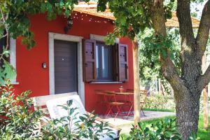 uma casa vermelha com uma mesa em frente em Agriturismo Poggio Degli Ulivi em Bomarzo