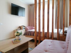 salon z 2 łóżkami i telewizorem w obiekcie Apartament NyX w mieście Floreşti