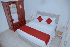 una camera da letto con un grande letto con cuscini rossi di Martin Aviator Hotel a Kigali