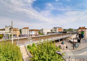 un puente sobre una ciudad con una vía de tren en Au PIED de la GARE aux PORTES de PARIS, en Vitry-sur-Seine
