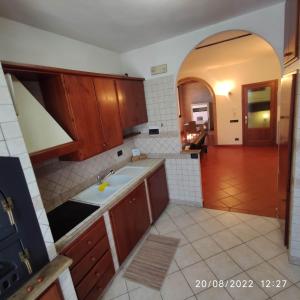 eine Küche mit Holzschränken und einem Waschbecken in der Unterkunft M & M Pinzi Suite Apartment in Montepulciano Stazione