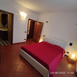 a bedroom with a large bed with a red blanket at M & M Pinzi Suite Apartment in Montepulciano Stazione
