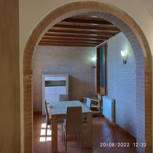 ein Esszimmer mit einem Tisch und einer Ziegelwand in der Unterkunft M & M Pinzi Suite Apartment in Montepulciano Stazione