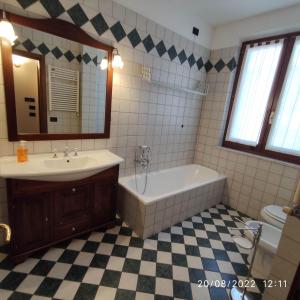 ein Badezimmer mit einer Badewanne, einem Waschbecken und einem Spiegel in der Unterkunft M & M Pinzi Suite Apartment in Montepulciano Stazione