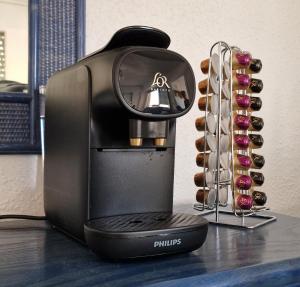 una cafetera sentada en una mesa junto a un estante de botellas de vino en Playa de Gandía, Gandía Beach, en Gandía