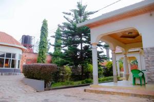 a gazebo with a green chair outside of a building at Martin Aviator Hotel in Kigali