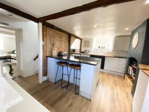 StalbridgeにあるHurst cottage, a cosy 2 bed cottage in Dorsetのキッチン(白いキャビネット、黒いカウンタートップ付)
