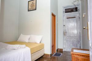 Habitación pequeña con cama y puerta en Hope Hotel Yogyakarta en Yogyakarta