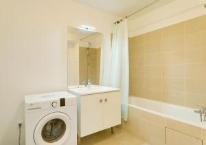 Un baño con lavadora y lavabo. en Au CALME entre DISNEY et PARIS, en Villiers-sur-Marne