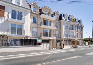 un gran edificio blanco al lado de una calle en Au CALME entre DISNEY et PARIS, en Villiers-sur-Marne