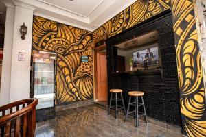 un bar con dos taburetes delante de una pared en Hope Hotel Yogyakarta en Yogyakarta