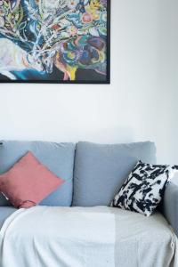 un sofá azul con almohadas encima en Au CALME entre DISNEY et PARIS, en Villiers-sur-Marne