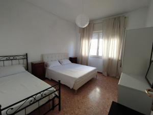 sypialnia z dwoma łóżkami i oknem w obiekcie Brezza marina w mieście Lido di Camaiore