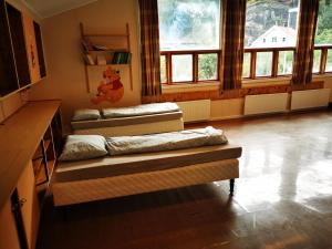 two beds sitting in a room with windows at Brufjell Hostel & Parking in Flekkefjord