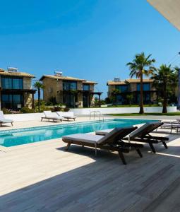 una piscina con tumbonas junto a un complejo en Villa Palma, en Kallithea Halkidikis