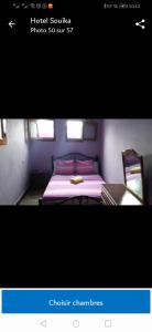a picture of a bedroom with a bed and a desk at Hotel Souika in Chefchaouene