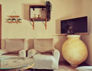 a living room with two chairs and a flat screen tv at CASA MOYA-LA ENCARNACIÓN in Caravaca de la Cruz