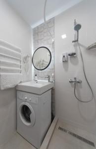 a white bathroom with a washing machine and a sink at MYFREEDOM Апартаменти метро Сирець in Kyiv