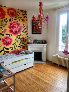 Zimmer mit einem Bett, einem Kamin und einem Kronleuchter in der Unterkunft Home Sweet Home in Baillet-en-France