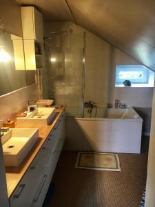 ein Badezimmer mit 2 Waschbecken, einer Dusche und einer Badewanne in der Unterkunft Home Sweet Home in Baillet-en-France
