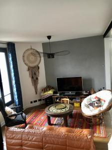 ein Wohnzimmer mit einem Sofa und einem TV in der Unterkunft Home Sweet Home in Baillet-en-France