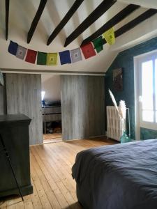 ein Schlafzimmer mit einem Bett und an der Decke hängenden Fahnen in der Unterkunft Home Sweet Home in Baillet-en-France