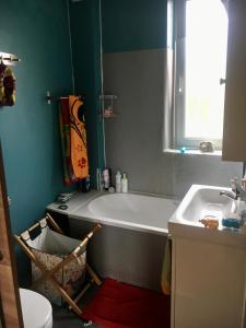 ein Badezimmer mit einer Badewanne und einem Waschbecken in der Unterkunft Home Sweet Home in Baillet-en-France